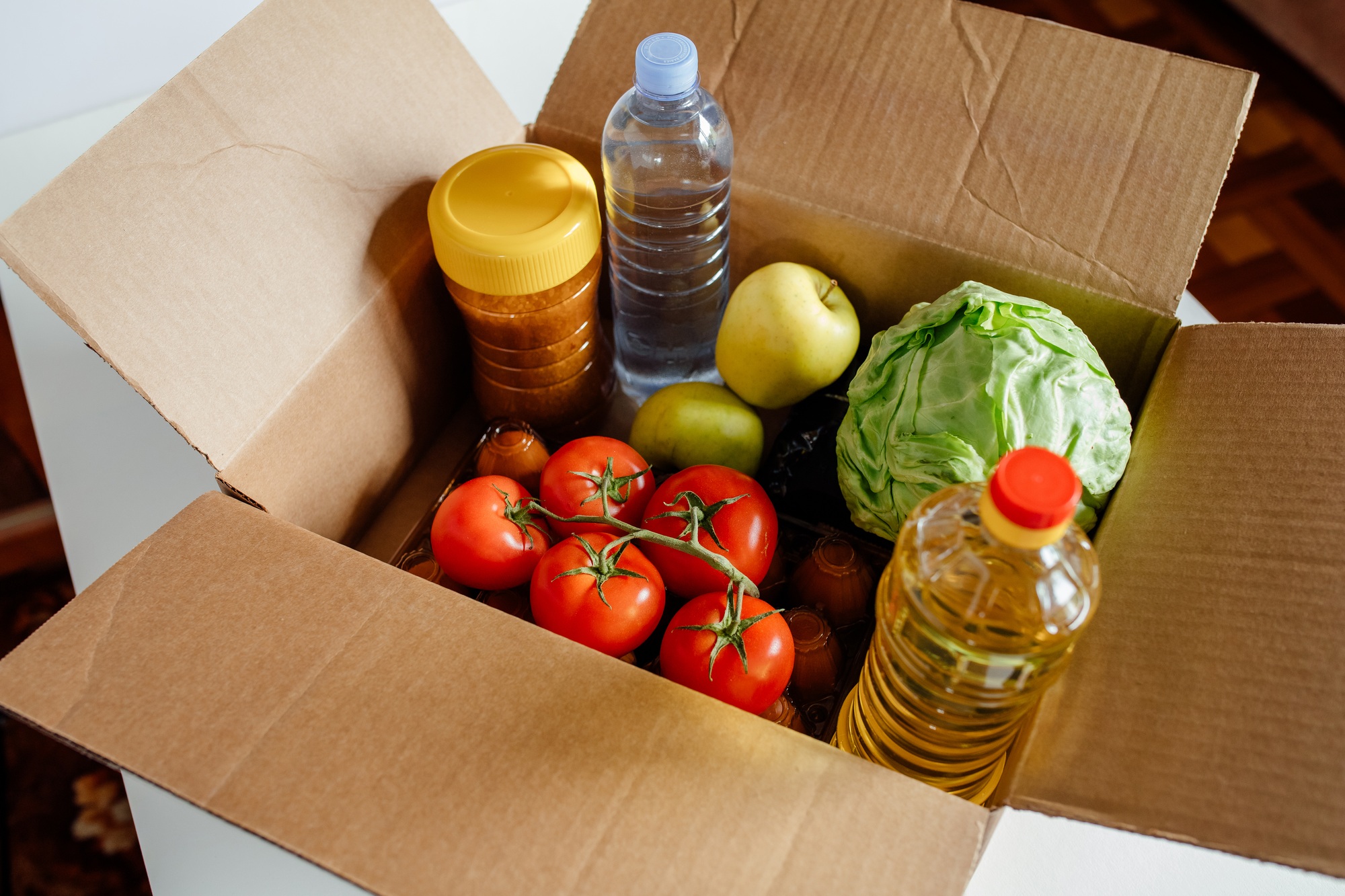 Close-up cardboard box with different fresh packed food products.